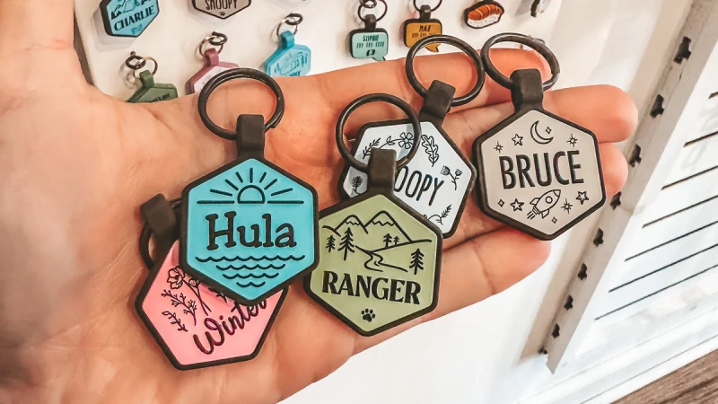 Hand holding colorful custom pet name tags.