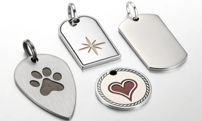 Quatre étiquettes métalliques pour animaux de compagnie avec différents motifs.