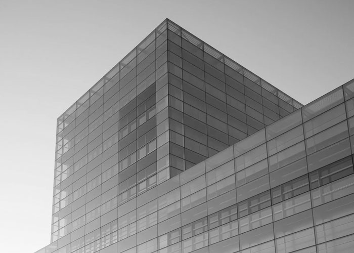 Immeuble de bureaux moderne en verre dans une vue en niveaux de gris.