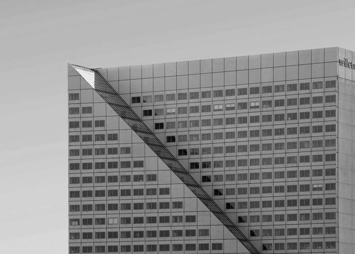 Dessin géométrique sur une façade de gratte-ciel moderne.