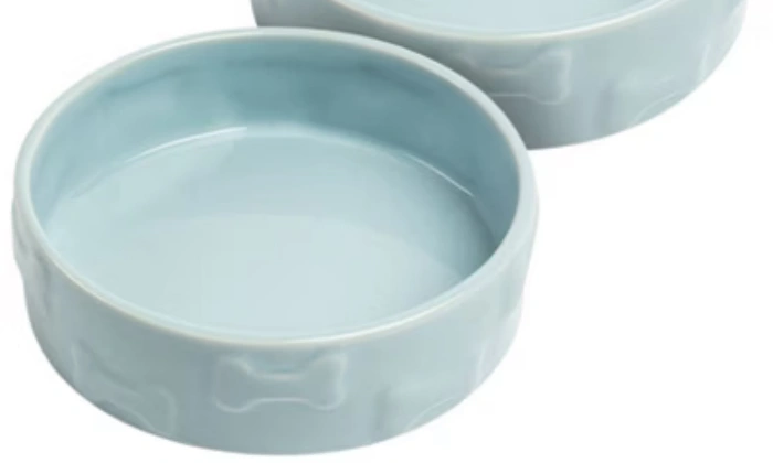 Zwei blaue Keramik-Hundenäpfe mit Knochenmotiven.